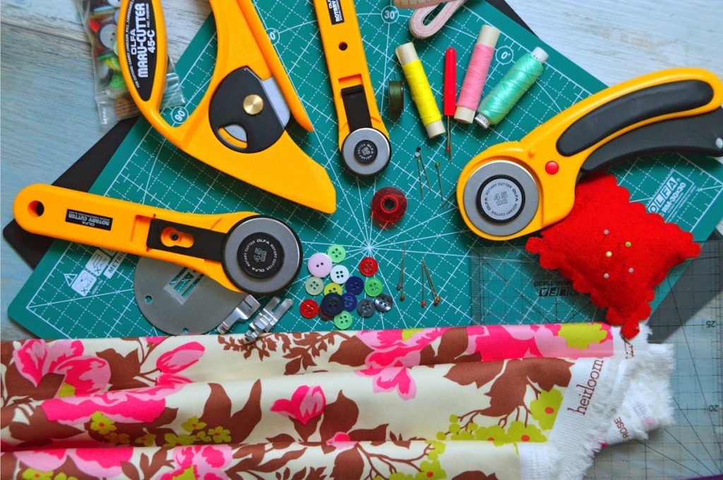 Quilting cotton fabrics, scissors and sewing tools laid out on a work table