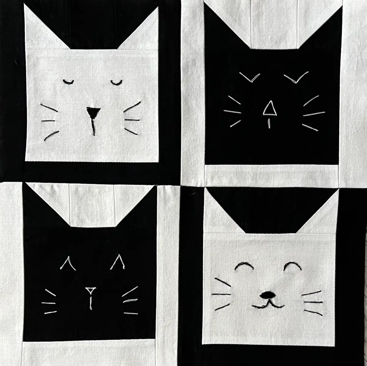 Cat face quilt blocks by Create Whimsy with embroidered features in black and white
